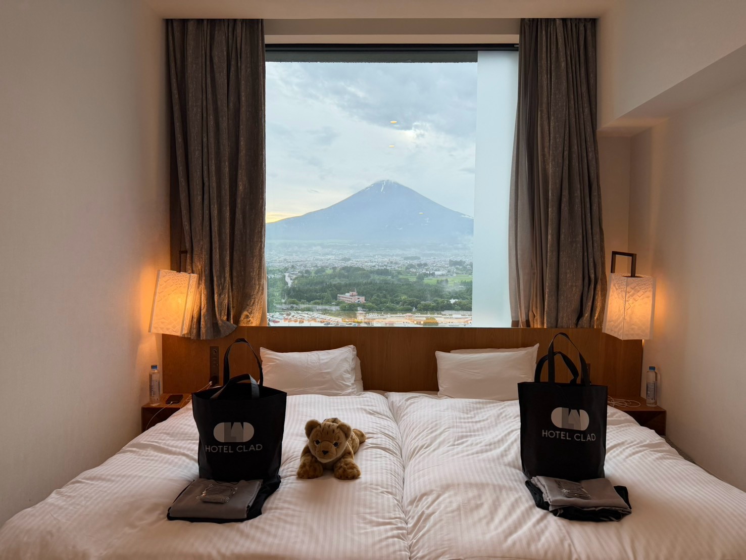 HOTEL CLAD 面富士山房型，床上放著提袋與小獅子玩偶